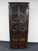 An oak leaded glass door corner display cabinet