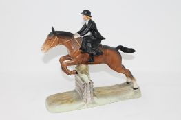 A Beswick figure of a huntswoman riding side saddle on a leaping horse, No.
