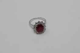 An 18ct white gold ruby and diamond cluster ring, size L.