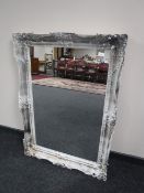 An ornate silvered framed mirror