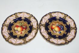 A pair of Royal Worcester gilt cabinet plates, painted with central panels of fruit, signed W.