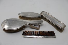 Three silver backed brushes together with a silver edged comb