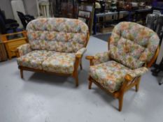 A two-piece wood framed cottage suite upholstered in a floral buttoned fabric