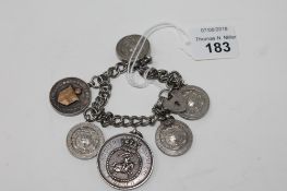 A silver padlock bracelet strung with sporting tokens and another loose token