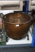 A large 19th century copper twin handled cooking pot on stand