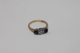 An 18ct gold three stone sapphire and diamond ring, the central stone weighing approximately 0.
