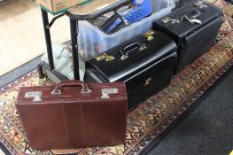Two black leather doctor's style bags together with a Burgundy leather briefcase