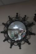 A wrought iron framed convex porthole mirror