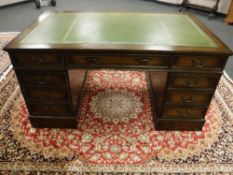 A Victorian style twin pedestal oak desk with green leather top