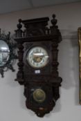 An early 20th century continental mahogany cased wall clock with enamelled dial