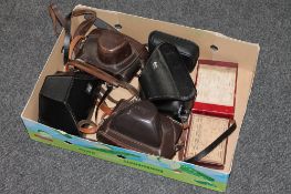 An Olympus trip 500 together with four Leica camera cases and two boxes of glass slides