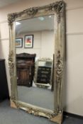 A large ornate silvered mirror 125 cm x 214 cm