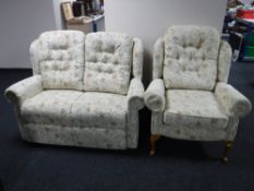A contemporary two seater settee and wing backed armchair upholstered in floral print