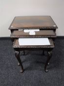 A nest of three mahogany glass topped tables on cabriole legs