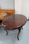 An oval mahogany dining table on cabriole legs