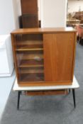 A mid twentieth century teak sliding glass door bookcase together with a retro two tier coffee