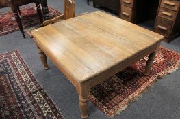 An antique pine square topped coffee table,