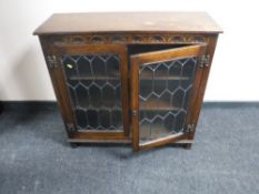 A twentieth century carved oak leaded glass door bookcase