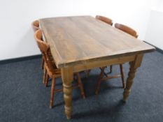 A rustic pine kitchen table together with four chairs