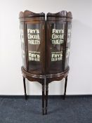 A pair of mahogany display cabinets with advertising writing.