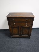 An Edwardian oak double door cupboard fitted with two drawers