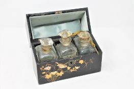 An early 20th century Japanese style lacquered three bottle scent decanter set,