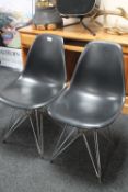 A pair of black plastic Vitra chairs on chrome legs