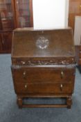 An early twentieth century carved oak writing bureau
