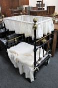 A Victorian cast iron and brass mounted doll's canopy bed, length 89 cm.