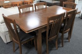 A Julian Bowen contemporary extending dining table together with six rail backed chairs