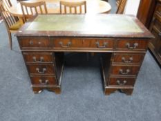 A mahogany twin pedestal writing desk with inset green leather panel