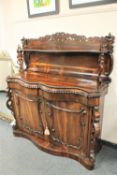An early 19th century rosewood serpentine fronted chiffonier, width 134 cm.