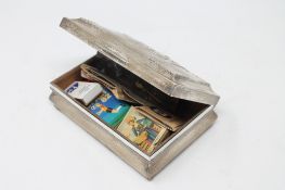 A silver cigarette box containing matchbooks
