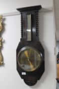 An oak barley twist aneroid barometer with brass dial