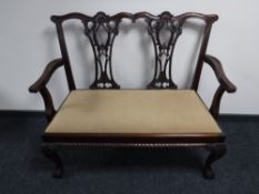 A reproduction mahogany Chippendale style two seater settee