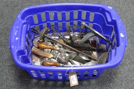 A basket containing assorted metal ware, including companion set, trivet, cutlery, carving set,