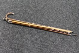 Three military swagger sticks together with a walking stick and cane with silver mounts and pommel