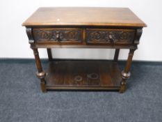 A twentieth century carved oak hall table fitted with two drawers and undershelf