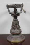 A weighted copper embossed table stand,