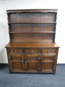 A carved oak triple door dresser