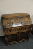 A carved oak linen fold bureau,