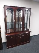 A triple door display cabinet fitted with cupboards and drawers beneath in a mahogany finish