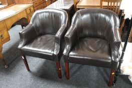 A pair of brown faux leather armchairs