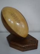 A wooden rugby ball on stand