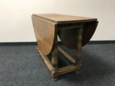 An early 20th century oak drop leaf table
