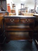 A set of inlaid mahogany shelves fitted two drawers