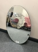An oval glass framed mirror