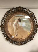 An ornate framed colour print depicting a lady in classical dress by a coast.