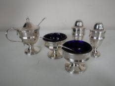 A five piece silver cruet set with spoons