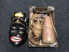 A box of two carved tribal masks, tribal drum, bowls, cow horns,
